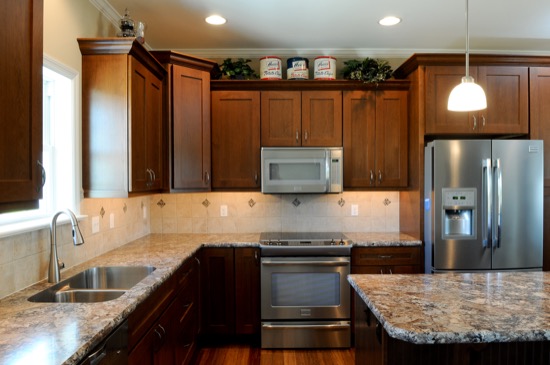kitchen with brown cabinets granite countertops, and stainless steel appliances