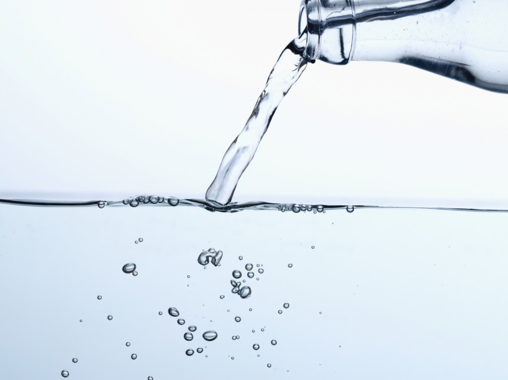 water bottle pouring into a pool of water