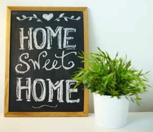 home sweet home on small chalkboard next to potted plant