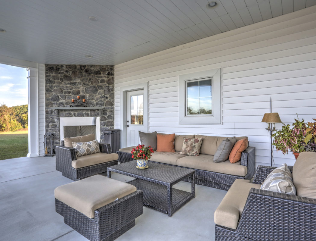 covered outdoor patio area with furniture and fireplace