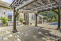 a shade structure on a finished patio and pool area