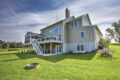 back of home with deck, sunroom, large yard and fire pit