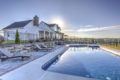 fenced in in-ground pool area with lounge chairs