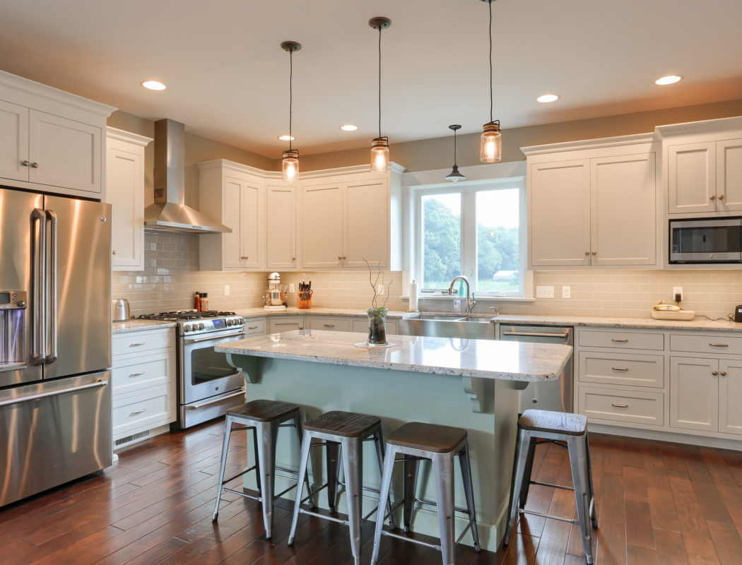 large, open kitchen with island and white cabinets