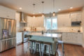 large, open kitchen with island and white cabinets