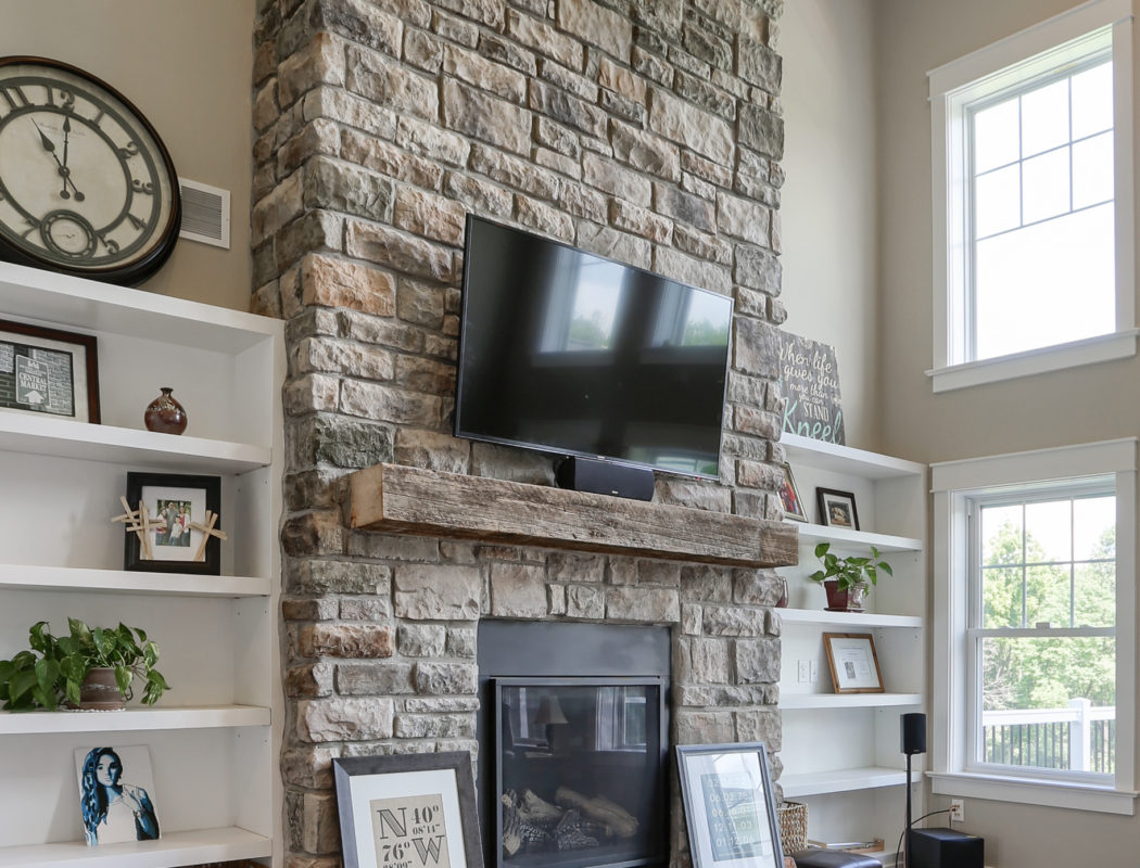 stone fireplace with mounted TV overhead