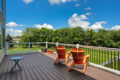 two orange chairs on a deck overlooking a lawn