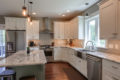 kitchen with island, white cabinets and stainless steel appliances