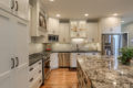 kitchen with white cabinets, large stone countertops and stainless steel appliances