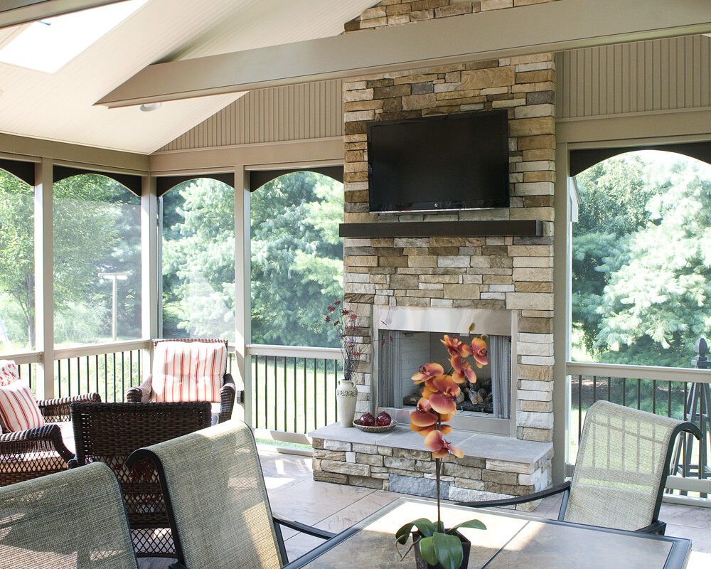 stone fireplace with a tv mounted above it