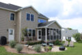 screened in porch, deck, and hardscaped patio behind a home