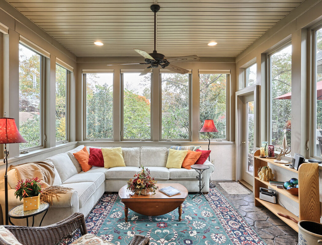 a sunroom with a wraparound couch