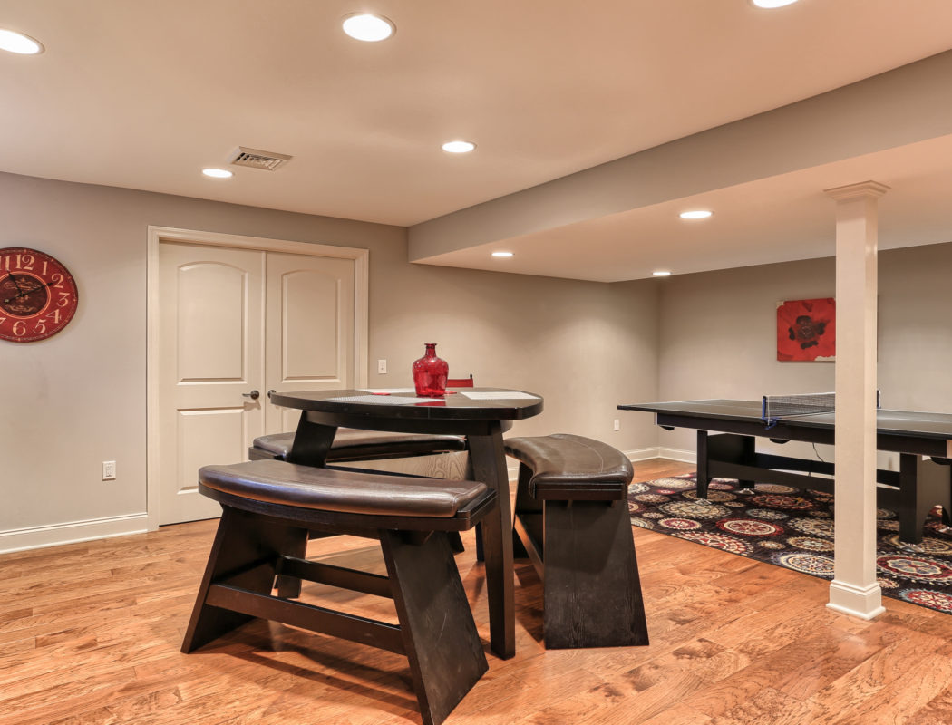 seating area with a pingpong table in the back of a recent Metzler Home Builders basement renovation