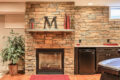 stone wall, fireplace, and refrigerator in a finished basement