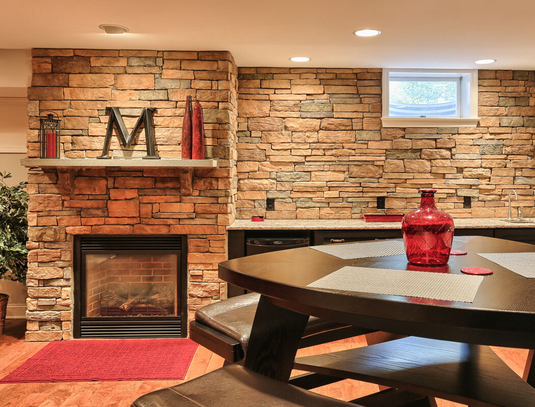 stone wall, fireplace, and seating area in a finished basement