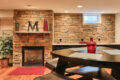 stone wall, fireplace, and seating area in a finished basement