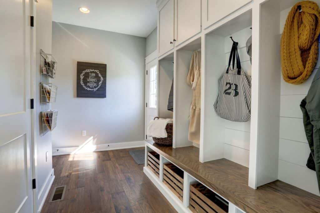 sample mudroom build by Metzler Home Builders. shows shelving for coats, bags and jackets and storage shelves underneath